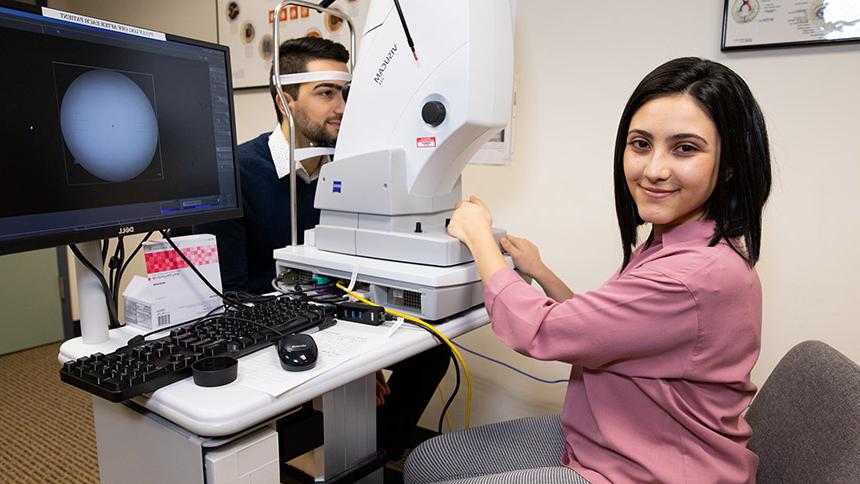 An optometry student examines a model patient in the EyeClinic